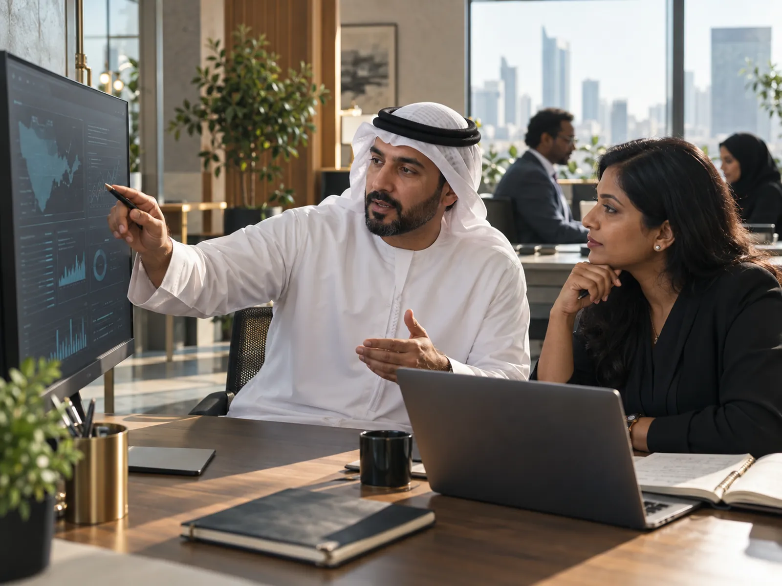 A planner explains a demand scenario on screen to a colleague.